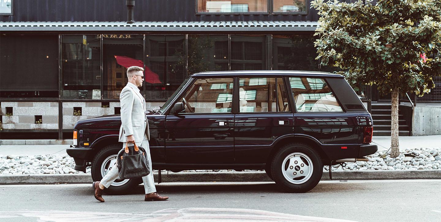 Man in a suit walking to Range Rover Classic